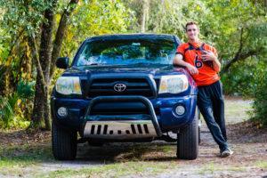 Central Florida Photographer-High School Senior with with football jersey and his truck in the woods.